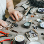Woman hands making handmade gemstone jewelry, home workshop. Woman artisan creates jewelry. Art, hobby, handcraft concept